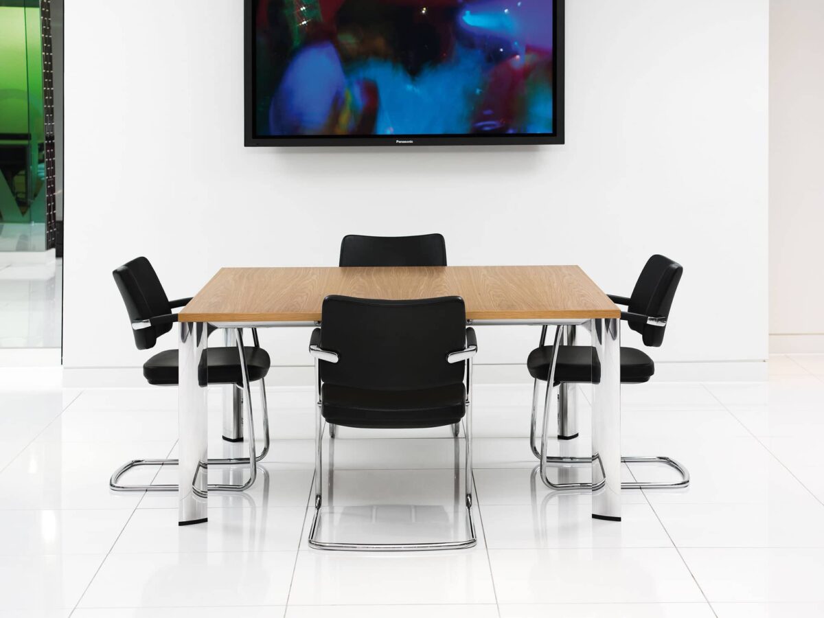 modern conference table with chrome legs and black chairs