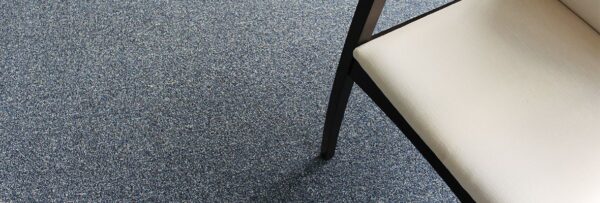 Overhead perspective view of a black legged chair resting on Passages carpeting.