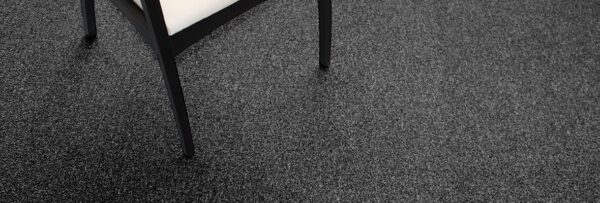 Studio shot of a black legged chair resting on Passages carpeting.