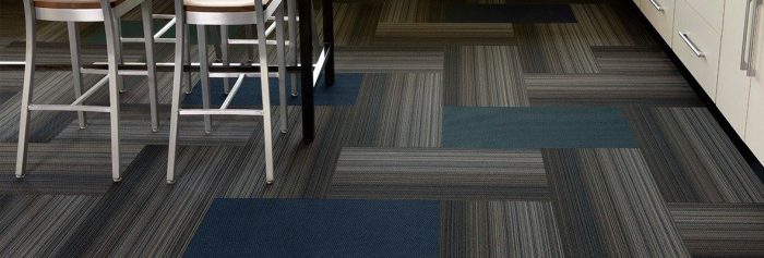 Studio shot of Umbra II carpeting in a classroom laboratory. The herringbone pattern is broken up with solid carpet squares. At the side, you can see one of the classroom benches, with tall chairs placed.