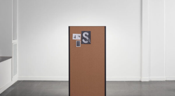 Studio shot of a single dB privacy panel. A set of notes and cards are pinned at the top.