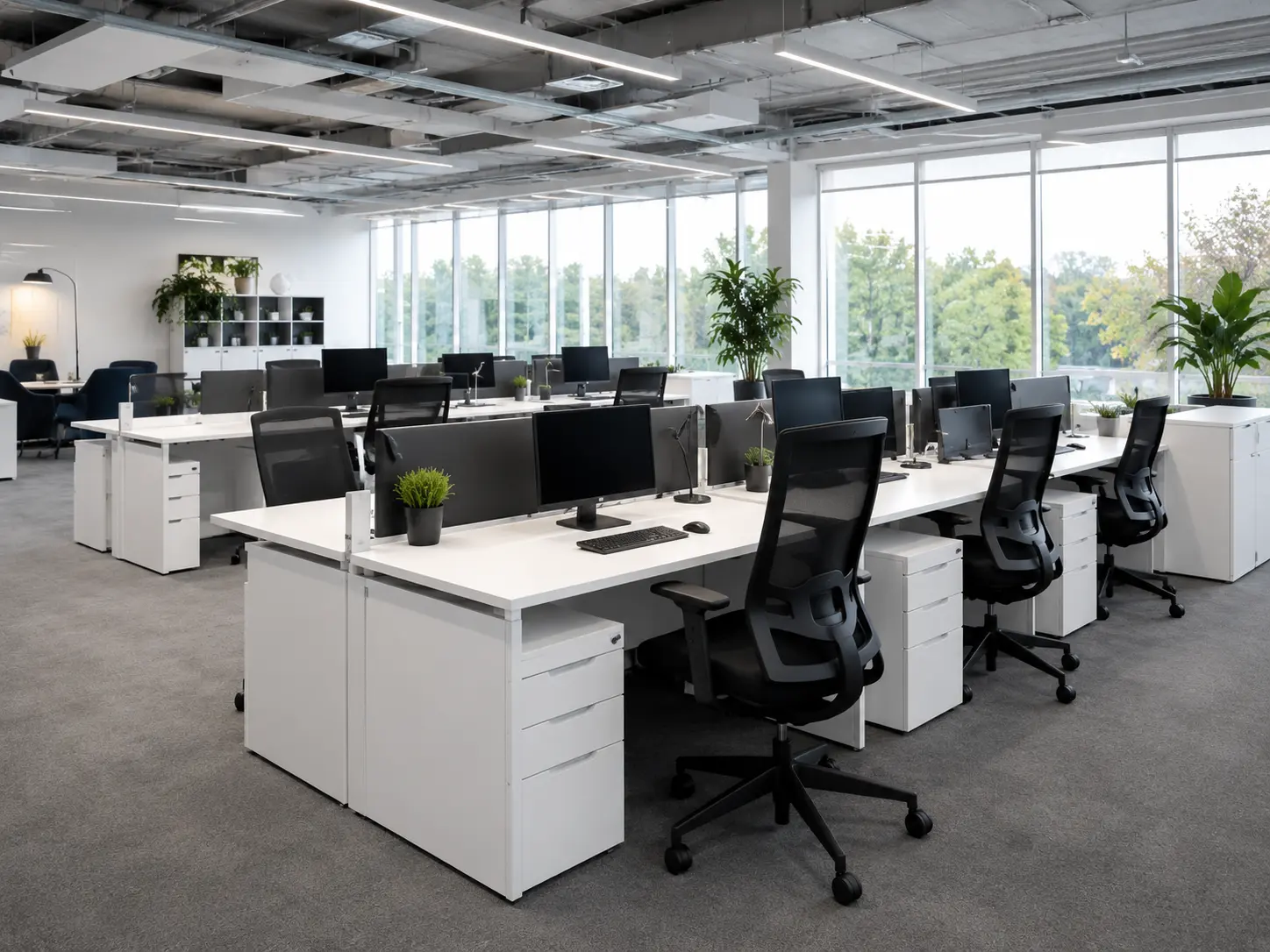 Open-plan office with white bench desks and black task chairs