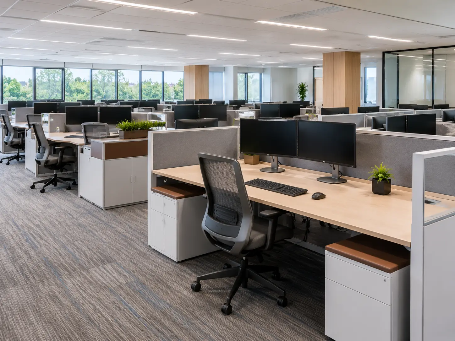 Modern office with rows of workstations and dual monitors