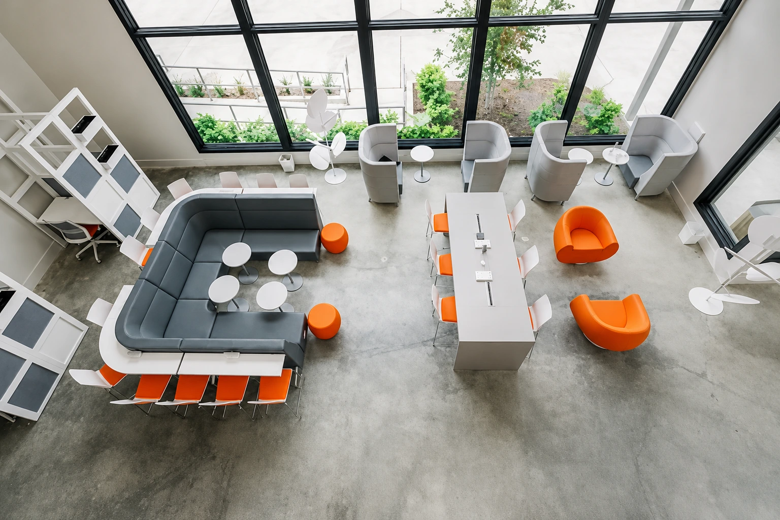 Team collaboration area with banquette seating, orange accents, and pendant lighting