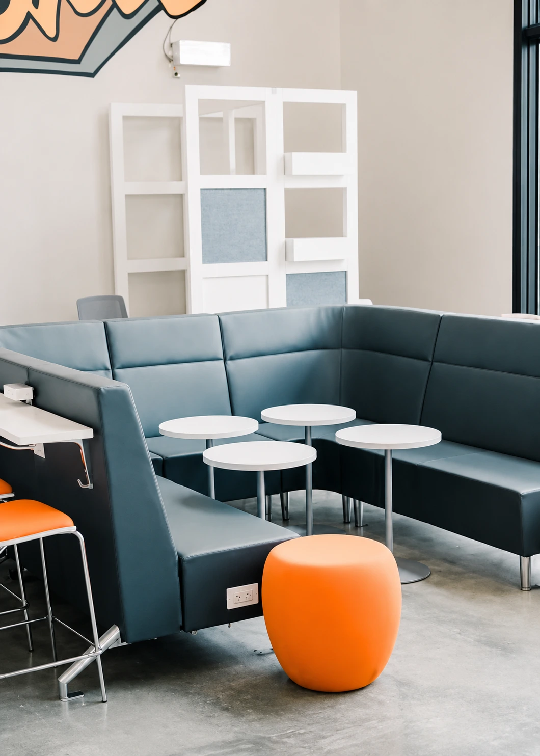 Glass-walled conference room with orange upholstered chairs at the Nan Properties headquarters in Houston Heights